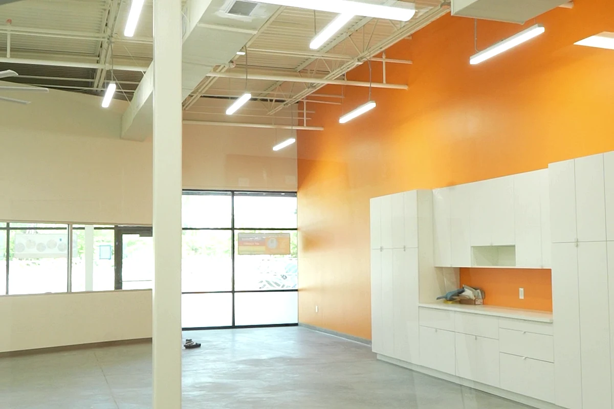 Completed children's play-space interior with orange feature wall and built-in cabinetry