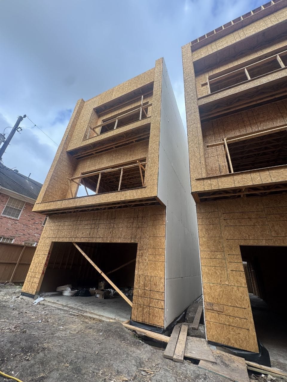 Four-story Houston townhomes under construction, sheathed and framed, during a townhome construction budget review